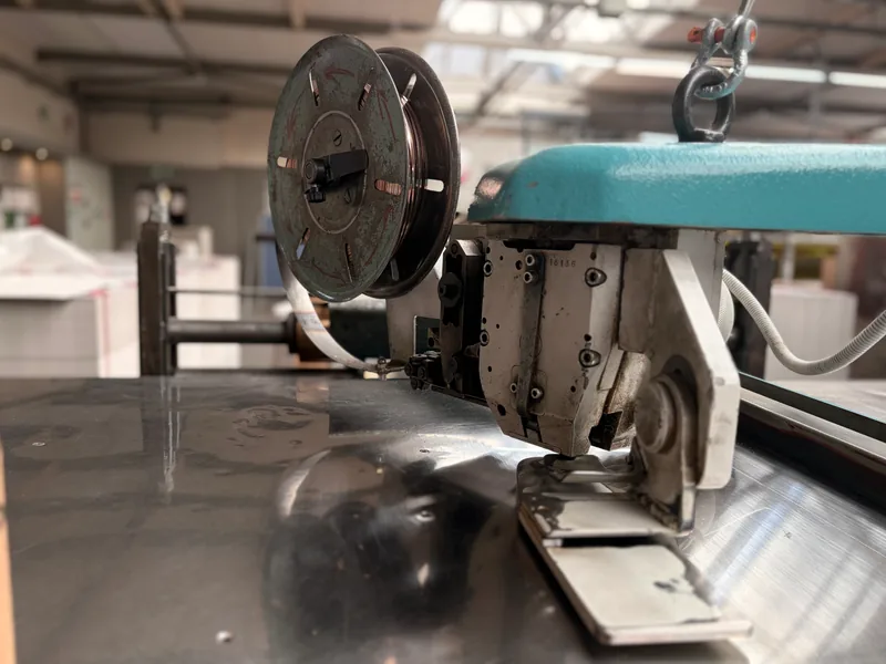 Heftmaschine mit Drahtspule und Heftkopf in der Produktion von HvC